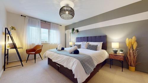 a bedroom with a large bed and a chair at Stylish Central Apartment in Beckenham