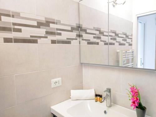 ein weißes Badezimmer mit einem Waschbecken und einem Spiegel in der Unterkunft Le Bradford YourHostHelper in Cannes