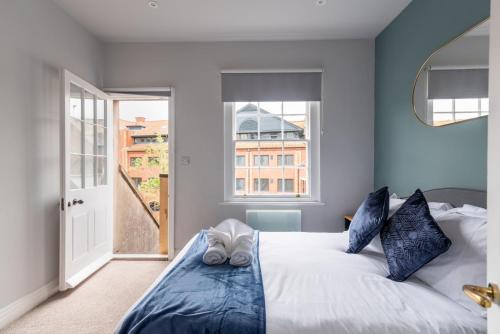 a bedroom with a bed with blue walls and a window at CoHost - Sky high in Bristol in Bristol