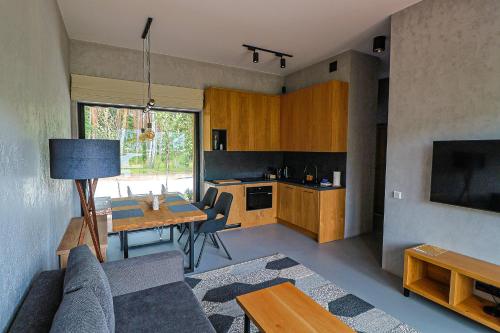 a living room with a couch and a table and a kitchen at Mana Lake in Sieraków