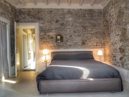 a bedroom with a bed and a stone wall at Boutique Stone House Vedasco in Stresa