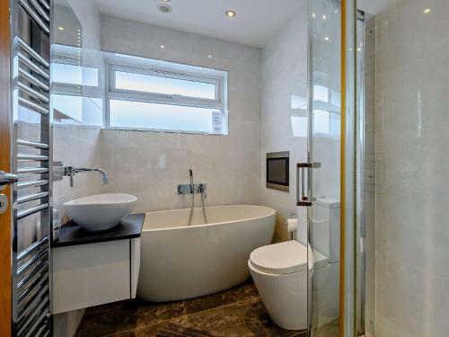 a bathroom with a tub and a sink and a toilet at 2 Bed in Mudeford 93458 in Christchurch