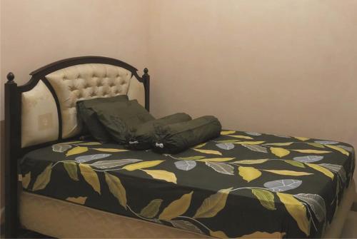 1 cama con edredón negro y amarillo en Griya Erlangga, en Kediri