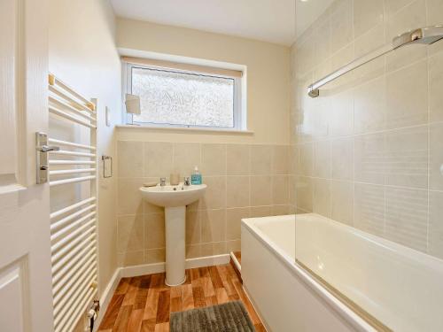 a bathroom with a sink and a bath tub and a sink at 3 Bed in Mudeford 93459 in Christchurch