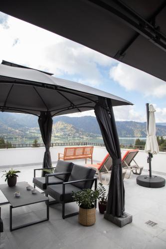 a patio with a large umbrella and chairs and tables at CASA ENCIAN in Colibiţa