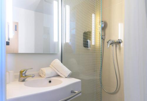 a bathroom with a sink and a shower at B&B HOTEL Nîmes Centre Arènes in Nîmes