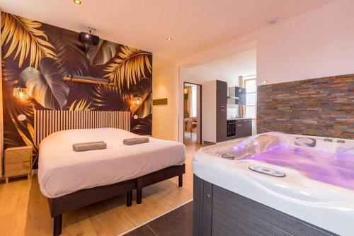 a bedroom with a bed and a bath tub at L'essentiel in Le Creusot