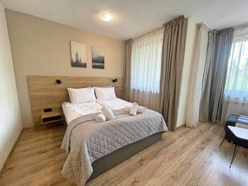 a bedroom with a bed with two towels on it at Arboro Borovets Gardens E50 in Borovets