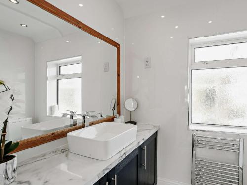 a white bathroom with a sink and a mirror at 3 Bed in Sutton on Sea SEALC in Sutton on Sea