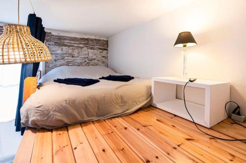 - une chambre avec un lit et une table avec une lampe dans l'établissement Le Perchoir de Niro, à Nantes