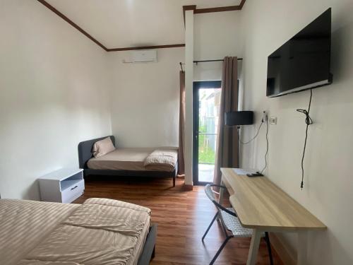 a bedroom with a bed and a desk and a couch at EMWEKA Residence Balikpapan in Balikpapan