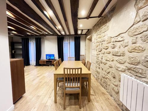 une salle à manger avec une table et un mur en pierre dans l'établissement Urban Flat 43 - Charming Parisian Flat near Grands Boulevards, à Paris
