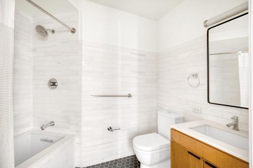 a white bathroom with a sink and a toilet at Midtown E 2br w elevator doorman gym nr UN NYC-752 in New York