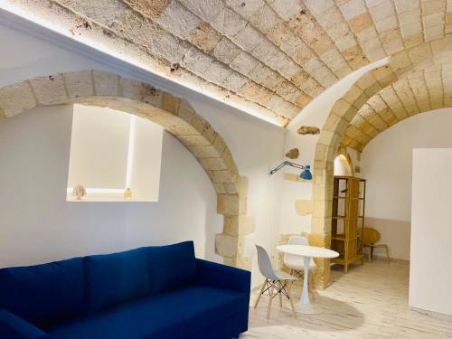 a living room with arched ceilings and a blue couch at La Bitta Suite in Brindisi
