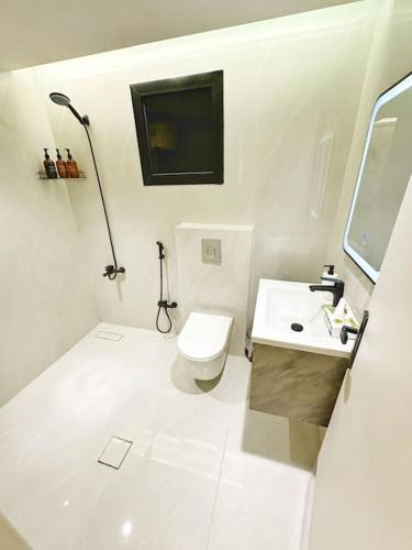 a white bathroom with a toilet and a sink at شقة بغرفتين نوم وبلكونة خاصة ١٥ in Riyadh