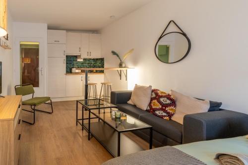 un salon avec un canapé et un miroir dans l'établissement Cosy Parisian Flat, à Paris