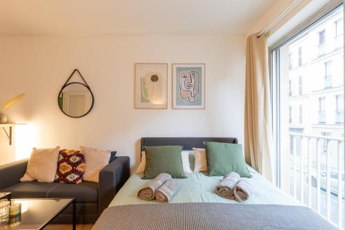 une chambre avec un lit, un canapé et une fenêtre dans l'établissement Cosy Parisian Flat, à Paris