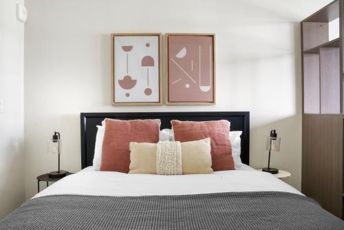 1 dormitorio con 1 cama con almohadas rosas y blancas en Blueground First Hill gym nr green spaces SEA-707, en Seattle