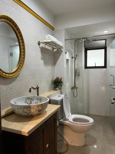 a bathroom with a sink and a toilet and a mirror at Quinstel Guesthouse in Bangkok