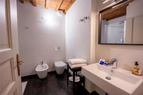 La salle de bains est pourvue d'un lavabo, de toilettes et d'un miroir. dans l'établissement Tuscan Palace - Avignonesi apartment, à Montepulciano