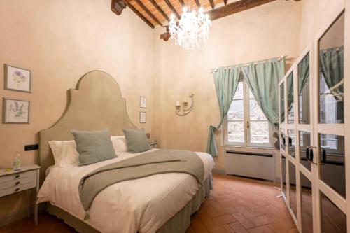 - une chambre avec un grand lit et un lustre dans l'établissement Tuscan Palace - Avignonesi apartment, à Montepulciano