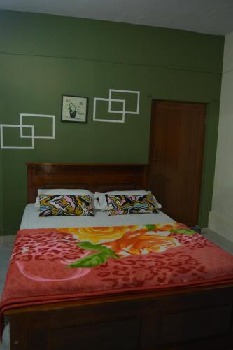 a bed in a room with a green wall at The Last Try - Secret Ashram Coorg in Siddapur