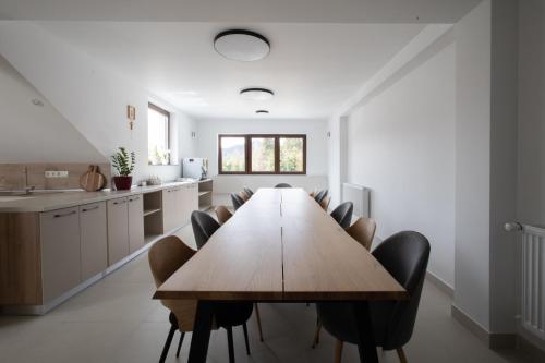 a dining room with a wooden table and chairs at CASA ENCIAN in Colibiţa