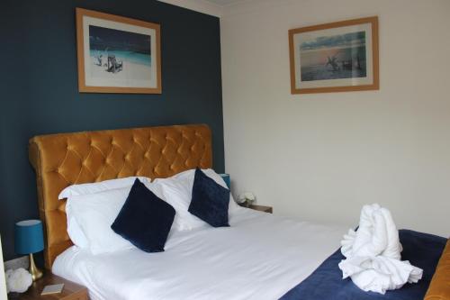 a bedroom with a bed with blue and white pillows at Oliver Wests Beautiful 1 Bedroom Retreat in Scarborough