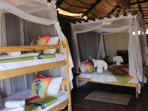 a room with two bunk beds in a house at Mukolo Cabins & Camping in Kongola