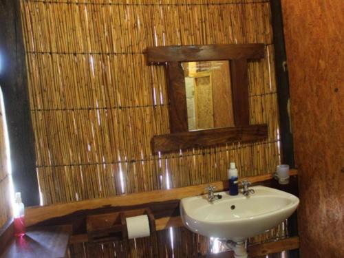 a bathroom with a sink and a mirror at Mukolo Cabins & Camping in Kongola