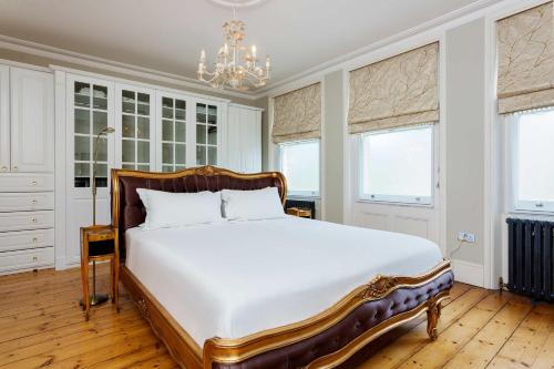 a bedroom with a large white bed with a chandelier at Veeve - Crystal Clear in London