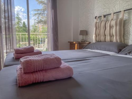 ein Schlafzimmer mit einem großen Bett mit rosa Handtüchern darauf in der Unterkunft Luninoso y práctico apartamento en el centro con amplio parking incluido in Granada