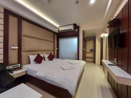 a bedroom with a large white bed and a television at New Gitanjali Hotel, New Digha in Digha