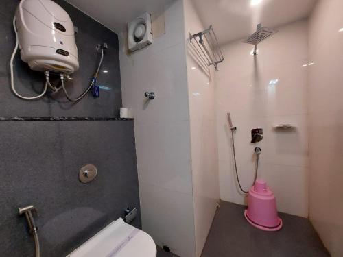 a small bathroom with a toilet and a shower at New Gitanjali Hotel, New Digha in Digha
