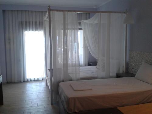 a bedroom with a bed with a canopy at Sea to See in Néa Péramos