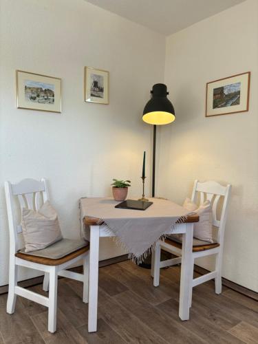 a dining room table with two chairs and a lamp at Heitmann`s Gasthof in Kirchlinteln
