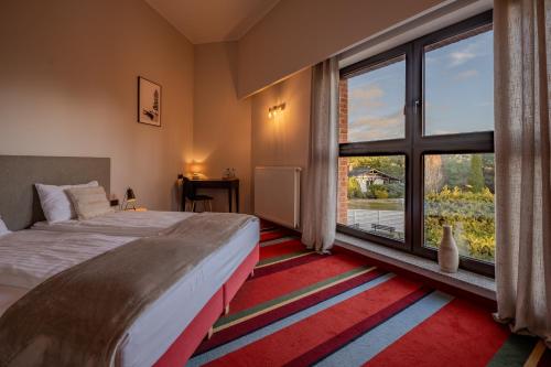 a bedroom with a bed and a large window at Hotel i Restauracja Czarny Kos in Borkowo