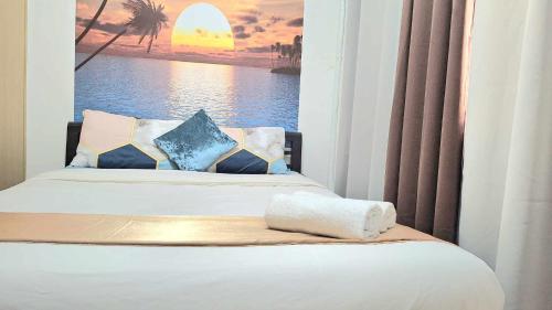 1 dormitorio con 1 cama con una foto del océano en Stylish 1BR with Wifi and Queen size bed in Grace Res en Manila