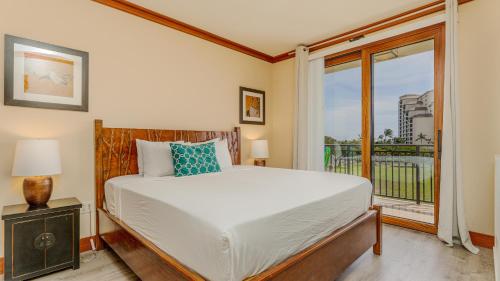 a bedroom with a bed and a large window at Ko Olina Beach Villas O425 in Kapolei