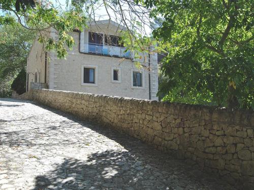 een gebouw achter een stenen muur naast een hek bij 'A Cunziria in Vizzini