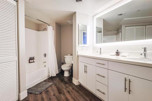 a white bathroom with a toilet and a sink at Huge & Bright 3BDR & 2BTH in SM - Free Parking in Los Angeles