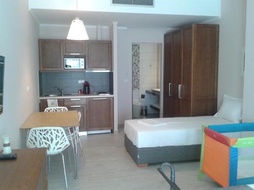 a small room with a bed and a kitchen at Sea to See in Néa Péramos