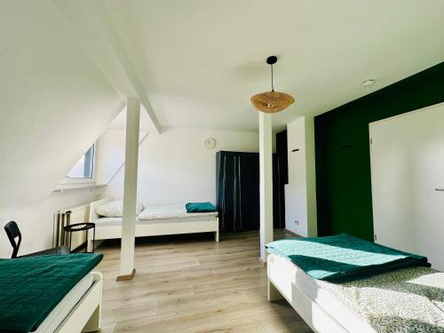 sypialnia z 2 łóżkami i zieloną ścianą w obiekcie Urban Green Appartement Hagen w mieście Hagen