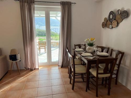 a dining room with a table and chairs and a window at Krios Guesthouse in Krotiri