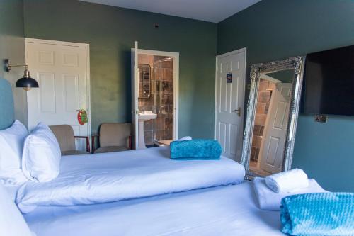 a bedroom with two beds and a mirror at The Plough Inn in Marsham