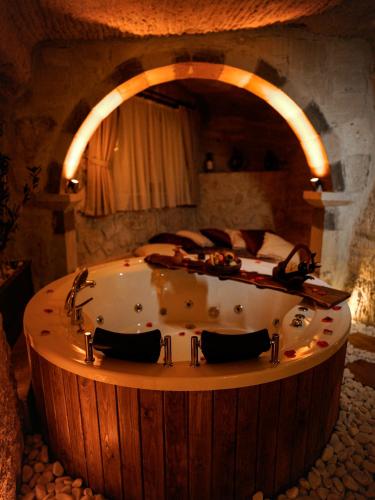 a bath tub in a room with a bed at Lost City Cappadocia in Nar