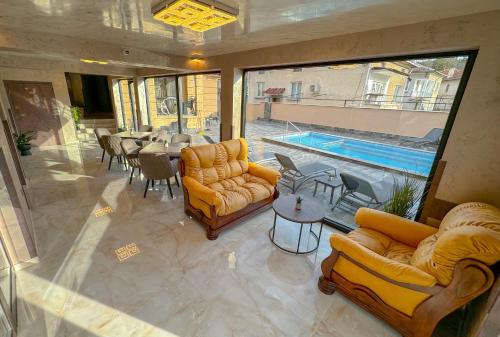 a living room with couches and a table and a pool at Стоичковата къща гр. Стрелча in Strelcha