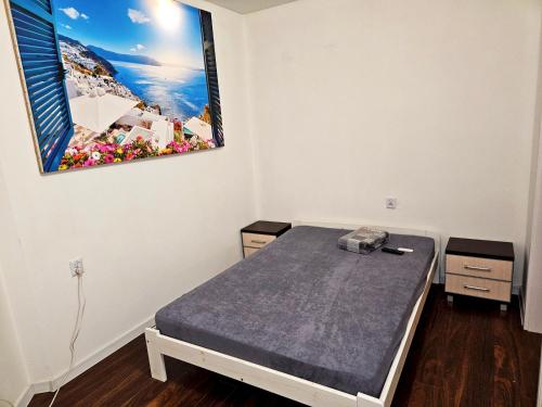 Zimmer mit einem Bett mit einem Bild an der Wand in der Unterkunft Apartament Moniuszki Starówka Bytom 40m2 in Bytom