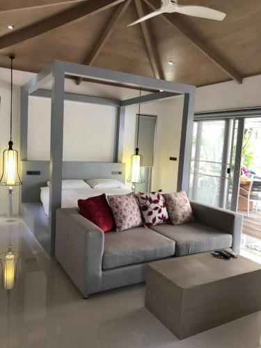 a living room with a couch and a bed at Baan Bangrak Garden in Koh Samui