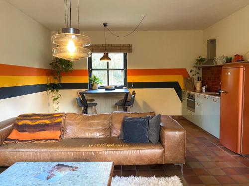a living room with a couch and a kitchen at Stay Classy in Otterlo